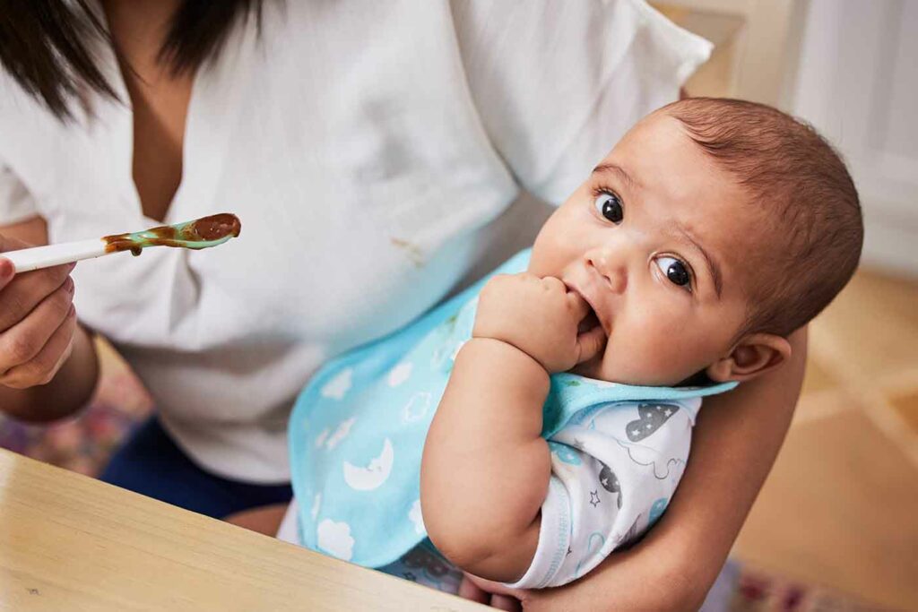 Its finger licking good. Shot of a mother feeding her adorable baby boy