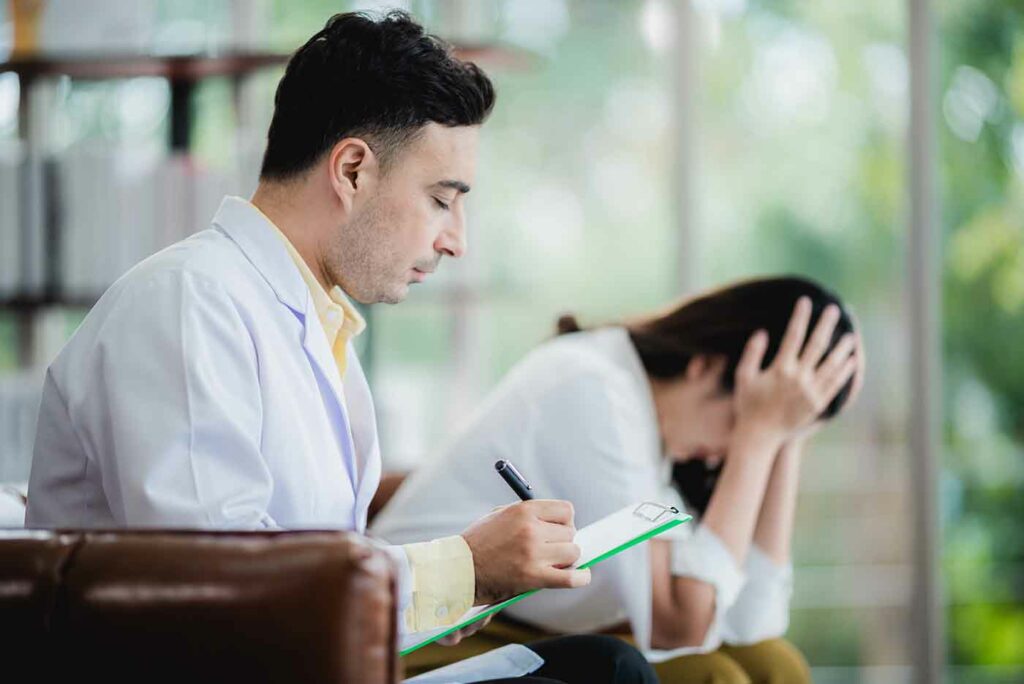 Close-up of psychologist comforting his depressed patient, mental health concept